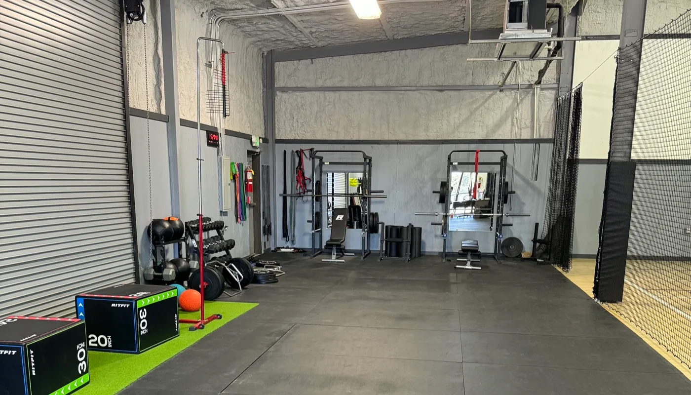 Liberty Hill Athletics private weight room with squat racks, benches, and free weights